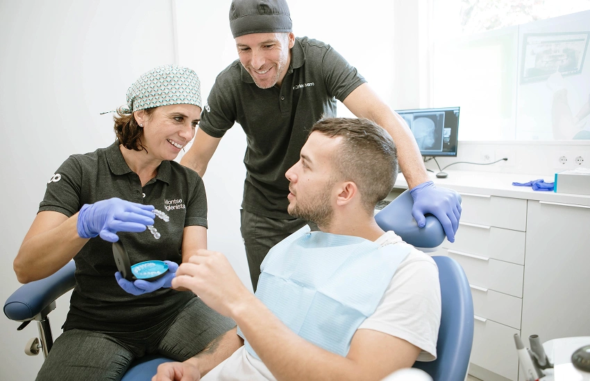 Ortodòncia sense ortodoncista: dentista mostrant alineadors transparents a un pacient a la consulta